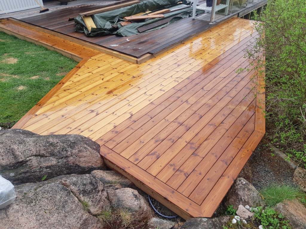 Nybygd treterrasse i flere nivåer med integrerte naturstein i hage.